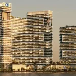 Three modern glass towers sit along a waterfront at sunset, with a sailboat visible on the left.